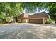 Exterior showcasing a side view of the home with an attached garage, surrounded by lush greenery at 1178 Roxboro Ne Cv, Atlanta, GA 30324