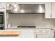A close-up of the kitchen with a tiled backsplash and stainless steel range hood at 1178 Roxboro Ne Cv, Atlanta, GA 30324
