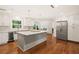 Spacious kitchen with a center island, stainless refrigerator, hardwood floors, and modern lighting at 1178 Roxboro Ne Cv, Atlanta, GA 30324