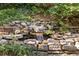 Beautiful rock water feature enhances the lush backyard landscape, adding a touch of tranquility at 1178 Roxboro Ne Cv, Atlanta, GA 30324
