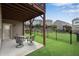 Backyard with lawn and patio, enclosed by a black wrought iron fence with a view of neighboring homes at 2251 Nancy Creek Dr, Atlanta, GA 30341
