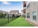Side view of the backyard, with lawn, a black wrought iron fence and view of the home's exterior at 2251 Nancy Creek Dr, Atlanta, GA 30341