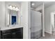 Functional bathroom with a dark vanity, large mirror, and shower-tub, with neutral paint and lighting at 2251 Nancy Creek Dr, Atlanta, GA 30341