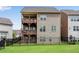 Back exterior view of home with multi-level balconies, fenced yard, and verdant lawn at 2251 Nancy Creek Dr, Atlanta, GA 30341