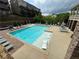 Community pool with lounge chairs, umbrellas, and sunbeds surrounded by a well maintained patio area and lush green landscape at 2251 Nancy Creek Dr, Atlanta, GA 30341