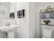Well-lit half bath with a pedestal sink, decorative towels, and a chrome towel rack at 537 Daffodil Ln, Mcdonough, GA 30253