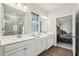 Bathroom featuring double sinks, modern fixtures, and a glass-enclosed shower, adjacent to the main bedroom at 537 Daffodil Ln, Mcdonough, GA 30253