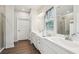 This bathroom has double sinks, modern fixtures, and a glass-enclosed shower with wood look flooring at 537 Daffodil Ln, Mcdonough, GA 30253