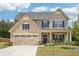 Charming two-story home boasts a well-manicured lawn, neutral siding, and a two-car garage at 537 Daffodil Ln, Mcdonough, GA 30253