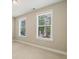 Bright bedroom featuring neutral walls, plush carpeting, and windows offering pleasant neighborhood views at 933 Catamaran Ct, Alpharetta, GA 30005