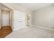 Bright bedroom with plush carpet, double closet and a view of ensuite bathroom, and hardwood hallway floors at 933 Catamaran Ct, Alpharetta, GA 30005