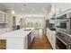 Spacious kitchen boasts a large island, stainless steel appliances, and wood flooring at 933 Catamaran Ct, Alpharetta, GA 30005