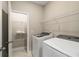 Well-lit laundry room featuring new front-load washer and dryer and shelving at 933 Catamaran Ct, Alpharetta, GA 30005