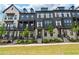 Modern townhomes with black siding, white brick, and well-manicured lawns at 933 Catamaran Ct, Alpharetta, GA 30005