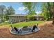 Backyard with a fire pit, four chairs, a lush green lawn, and a gray brick home at 1154 Pair Sw Rd, Marietta, GA 30060