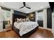 Chic bedroom boasts a dark accent wall, hardwood floors and elegant fixtures at 1154 Pair Sw Rd, Marietta, GA 30060