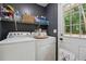 Laundry room features a gray accent wall, white door, and a white washer and dryer at 1154 Pair Sw Rd, Marietta, GA 30060