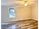 This bedroom offers wood-look flooring, a ceiling fan, neutral paint, and a window for lots of natural light at 3211 Oaktree Park Dr, Lawrenceville, GA 30044