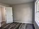 Inviting bedroom with wood-look floors, a window for natural light, bright white trim, and neutral colored paint at 3211 Oaktree Park Dr, Lawrenceville, GA 30044