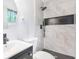 Modern bathroom with tiled walk-in shower, black fixtures, and a round mirror at 3901 Bonnie Se Ln, Atlanta, GA 30354