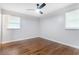 Cozy bedroom featuring hardwood floors, a ceiling fan, and bright natural light from two windows at 3901 Bonnie Se Ln, Atlanta, GA 30354