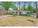 Quaint blue brick home featuring a sunny yellow door and covered parking, surrounded by lush greenery at 3901 Bonnie Se Ln, Atlanta, GA 30354