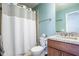 This bathroom has a shower with a white curtain, a toilet, and a vanity with a brown cabinet at 2580 Acorn Ne Ave, Atlanta, GA 30305
