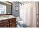 Bathroom boasts dark wood cabinets, granite counters, tiled shower with a curtain at 2580 Acorn Ne Ave, Atlanta, GA 30305