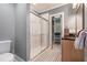 Bathroom with white tiled shower, a single vanity, and an adjacent closet with shelving at 2580 Acorn Ne Ave, Atlanta, GA 30305