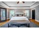 Spacious bedroom with tray ceilings, hardwood floors, bench, and access to a private balcony at 2580 Acorn Ne Ave, Atlanta, GA 30305