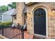 Close-up of a brick house with a black arched front door and a porch with two chairs at 2580 Acorn Ne Ave, Atlanta, GA 30305