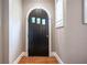 Interior shot of a black arched wooden front door with sidelight, wainscoting, and hardwood floors at 2580 Acorn Ne Ave, Atlanta, GA 30305