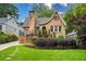 Charming brick home with a manicured lawn, garden bed, and front porch featuring black iron railings at 2580 Acorn Ne Ave, Atlanta, GA 30305