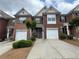 Traditional brick townhome featuring attached garage and manicured landscaping at 3871 Pleasant Oaks Dr, Lawrenceville, GA 30044