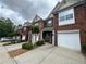 Traditional brick townhomes featuring attached garages and driveway at 3871 Pleasant Oaks Dr, Lawrenceville, GA 30044