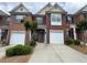Traditional brick townhome featuring attached garage and manicured landscaping at 3871 Pleasant Oaks Dr, Lawrenceville, GA 30044