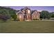 Beautiful two-story brick home with a manicured lawn and mature trees at 400 Kyle Ct, Fayetteville, GA 30215
