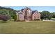 Beautiful two-story brick home with a manicured lawn and mature trees at 400 Kyle Ct, Fayetteville, GA 30215