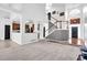 Open-concept living room features a staircase, kitchen view, and natural light at 400 Kyle Ct, Fayetteville, GA 30215