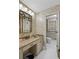 Bathroom with floral wallpaper, large mirror, and vanity with a beige countertop and a peek at the toilet in separate area at 681 Hampton Sw Pl, Marietta, GA 30064