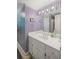 Bathroom with white vanity and sink, a large mirror, and wallpaper featuring purple vertical stripes at 681 Hampton Sw Pl, Marietta, GA 30064