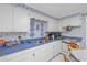 Galley kitchen with blue countertops, white cabinets, decorated with blue floral wallpaper at 681 Hampton Sw Pl, Marietta, GA 30064