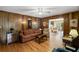 Warm living room featuring wood-paneled walls, comfortable seating, and seamless access to a bright sunroom at 681 Hampton Sw Pl, Marietta, GA 30064