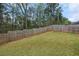 Spacious backyard featuring lush lawn enclosed by a tall wooden privacy fence and woods at 1612 Nations Trl, Riverdale, GA 30296