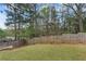 The backyard features a gentle slope, lawn, and a tall wood fence at 1612 Nations Trl, Riverdale, GA 30296