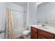Bright bathroom features a shower-tub combo and a cherry wood vanity at 1612 Nations Trl, Riverdale, GA 30296