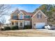 Inviting two-story home with stone detailing, lush landscaping, and a spacious driveway with a parked car at 190 Country Club Dr, Hiram, GA 30141