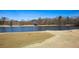 Golf course with pond and flags in the community on a clear day with a fountain in the water feature at 190 Country Club Dr, Hiram, GA 30141