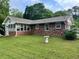 Brick exterior showing the side and back of the home with a grassy yard space and mature trees at 2659 Odum St, Snellville, GA 30078