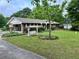 Landscaped front yard featuring a quaint swing and lush greenery complementing this charming brick home at 2659 Odum St, Snellville, GA 30078